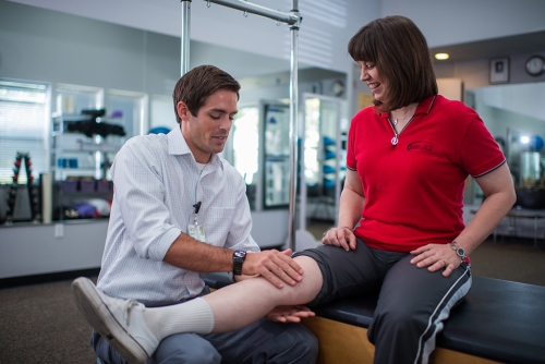 therapist attending to woman's knee